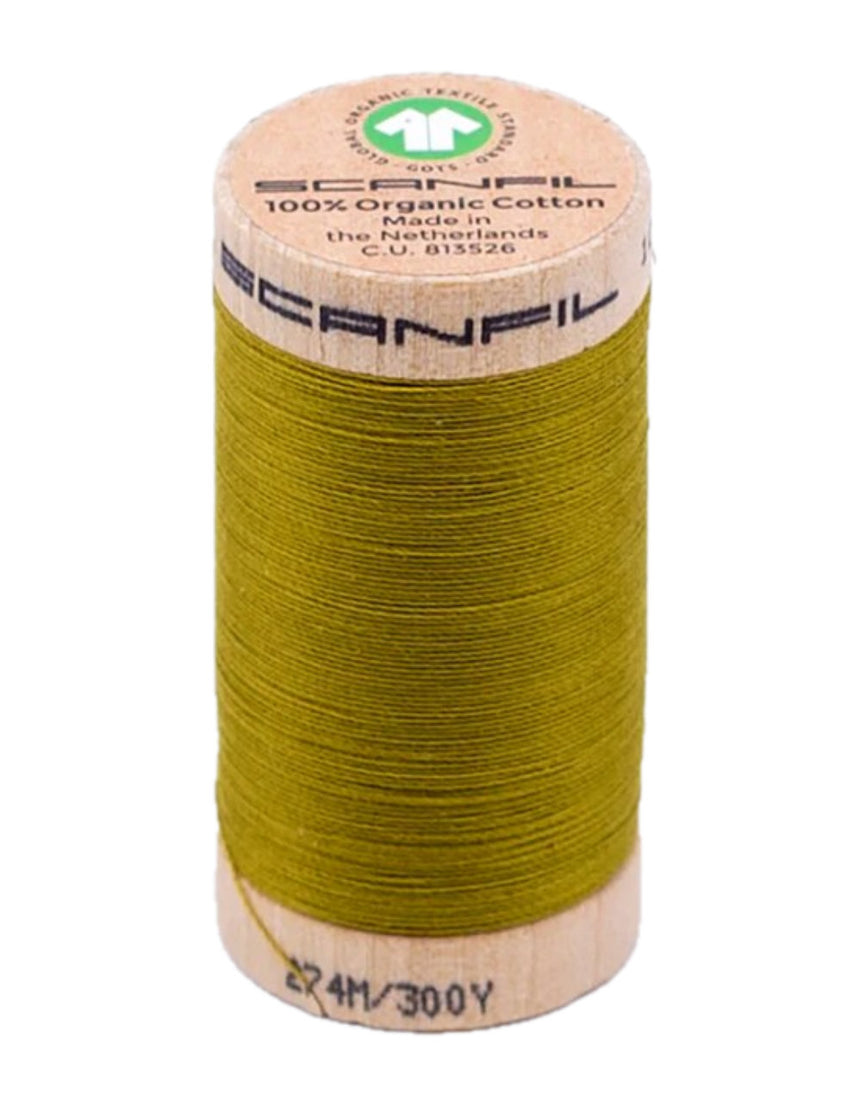 Spool of green thread with a wooden spool and brand label on a white background